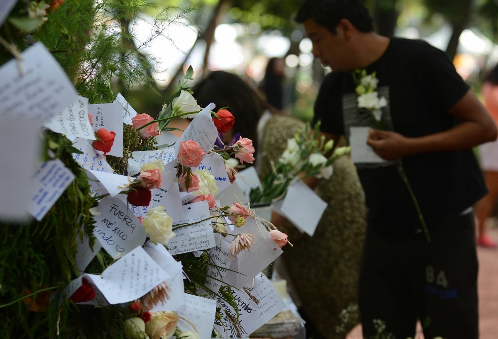 MEXICO-QUAKE-MEMORIAL People start a memorial with flowers at a park in front of one of the collapsed buildings in Mexico city on September 23, 2017.
In the capital, the quake toppled 39 buildings, mostly in a central area with older construction that is popular with tourists and foreigners living in the city, and also in the south. / AFP PHOTO / LUIS PEREZ (Photo credit should read LUIS PEREZ/AFP/Getty Images)