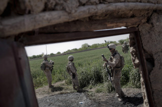 A US Marine (2nd R) of 3rd Battalion, 6th Marines checks their position on a GPS device as they move forward at a farm during a foot patrol in Marjah, Helmand province, on April 3, 2010.