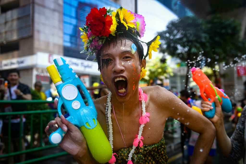 THAILAND-FESTIVAL-SONGKRAN-NEW YEAR A reveller wearing a colorful costume holds a toy water gun during a mass water fight in celebration of Songkran, or Thai New Year, on Silom Road in Bangkok on April 13, 2018.