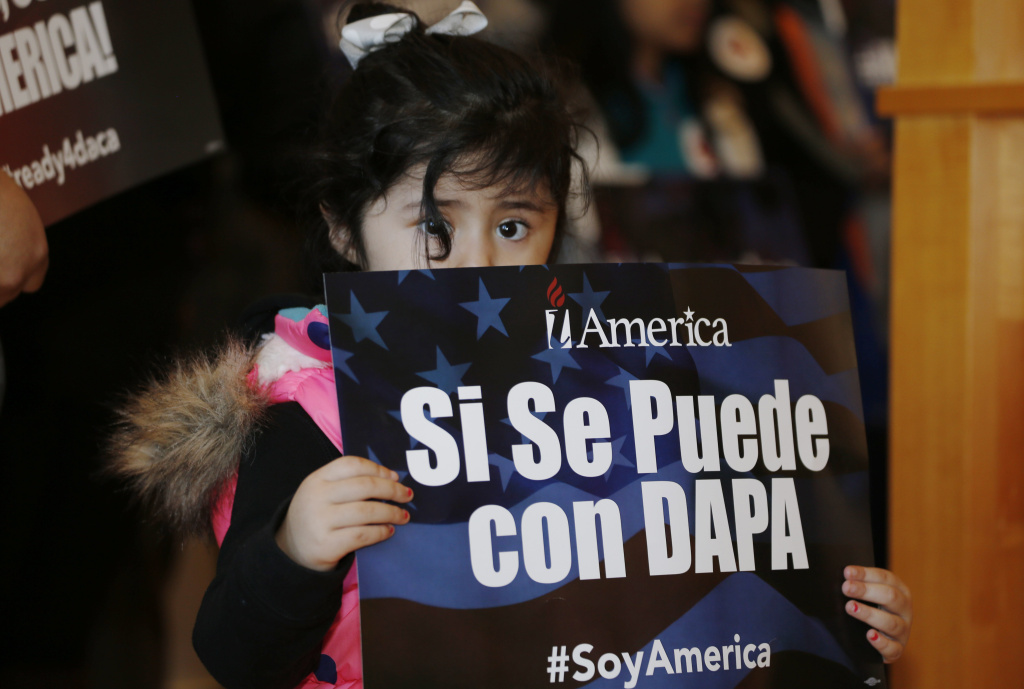 Immigration Lawsuit Three-year-old Genesis Moreno Betancurth, of Denver, holds a placard during a news conference in the Denver Public Library, Tuesday, Feb. 17, 2015, in Denver. The White House promised an appeal Tuesday after a federal judge in Texas temporarily blocked President Barack Obama's executive action on immigration and gave a coalition of 26 states time to pursue a lawsuit aiming to permanently stop the orders. (AP Photo/David Zalubowski)