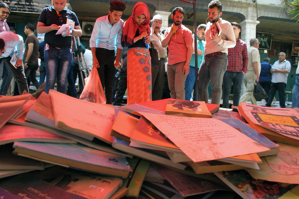 IRAQ-CONFLICT Iraqis buy books at an open-air market in the capital Baghdad's Mutanabi Street on May 5, 2017, to donate them to the University of Mosul's library, as part of an initiative to replenish the institution after its documents were destroyed by ISIS.