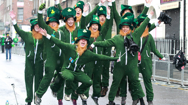 Parade-goers dressed as leprechauns jump up and shout as they prepare to attend St. Patrick's Day festivities in Dublin.