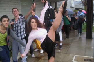 Mercer 6604 Jamie Goodwin kicks high as Robert Roldan and Adrian Lee wait in line to audition to dance on the Academy Awards show.