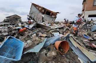 Rescue workers look on March 14, 2011, for missing people in Natori, Miyagi Prefecture, following the tsunami and earthquake on March 11.