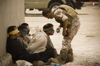 An Iraqi soldier from 2nd Division gives water to detainees after returning to their base from a morning mission on June 5 , 2010 in Mosul, Iraq.