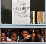 School children stand under a drawing on Jan. 27, 2011 in the vicinity of Milpark Hospital in Johannesburg, South Africa where former President Nelson Mandela was admitted for routine tests.