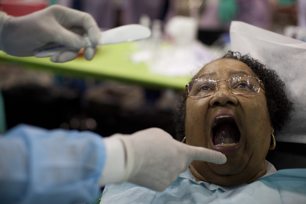 FREE CLINIC 001 Dr. Paul Schafer begins to make a mold for patient Ida Franklin during a free health clinic at the L.A. Sports Arena. Despite greater access to health insurance through the Affordable Care Act, the program will see 1,000 each day over the four-day event.