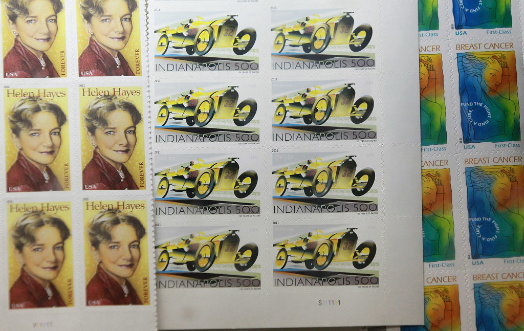 US Postal Service Details New Cost Cutting Plan US Postal Service stamps are displayed at a US Post Office on December 5, 2011 in San Francisco, California. The US Postal Service announced today that they are considering a plan to eliminate the first class next-day delivery for stamped letters as well as closing half of its 487 mail processing plants across the country in an effort to cut costs and avoid bankruptcy.