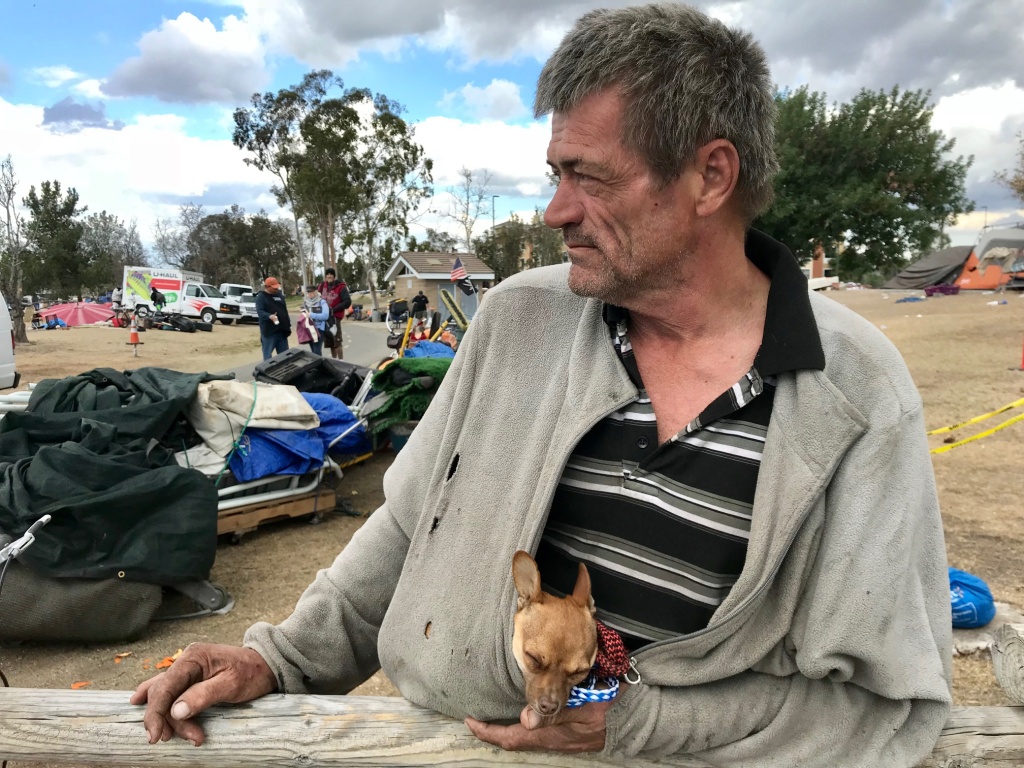 OC riverbed homeless Fritz Reichenbach waits along the Santa Ana River to board a van for a motel in Buena Park where he'll stay for 30 days.