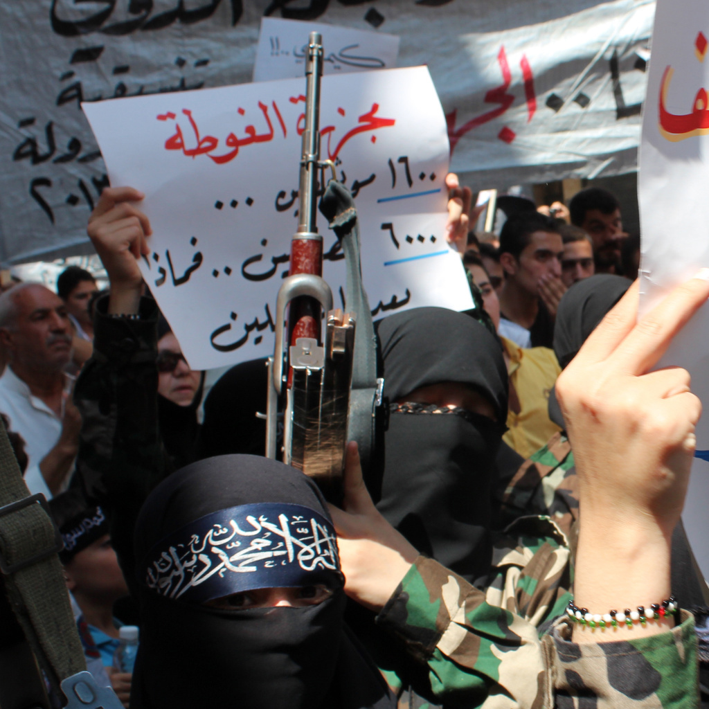 Female rebel fighters gather in Syria's northern city of Aleppo on Saturday to protest what they claim was a chemical attack by pro-government forces in a suburb of Damascus.