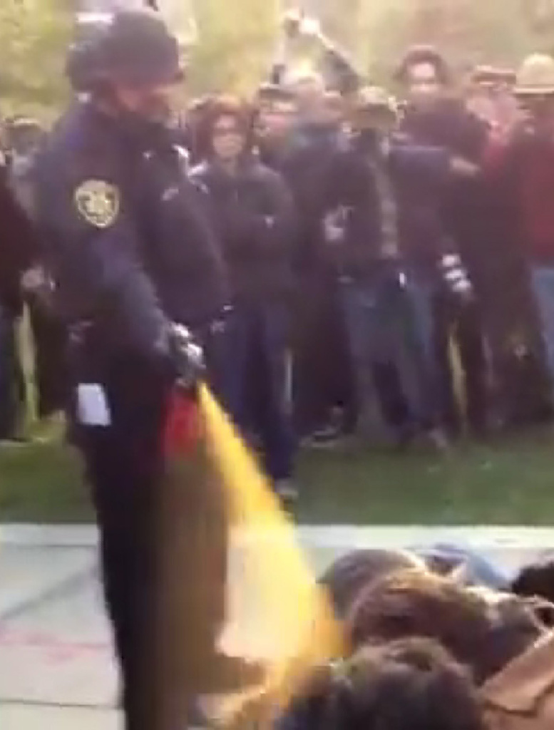 A police officer uses pepper spray on seated Occupy demonstrators at the University of California, Davis, on Nov. 18, 2011.