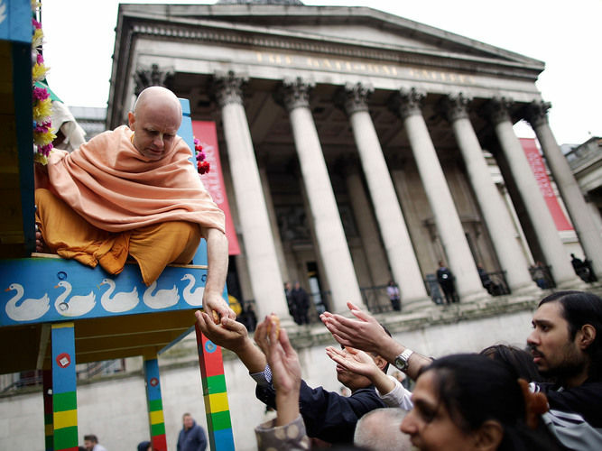 A Hare Krishna distributes food gifts from a chariot during a festival in London in 2011. The religious group began distributing books, flowers and gifts to strangers in the 1970s, drawing on the rule of reciprocation to raise money.
