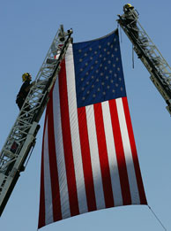 File photo: Firefighters hang an American flag over the route of the funeral procession for fallen Los Angeles Police Department (LAPD) SWAT Officer Randal Simmons, the first LAPD Swat officer ever killed in the line of duty in the 41-year history of the special operations team, on February 15, 2008 in Los Angeles, California.