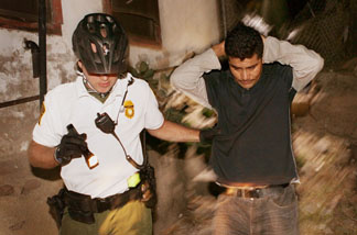 An U.S. Customs and Border Protection bike patrol agent apprehends an undocumented immigrant after he was spotted entering the country illegally June 2, 2010 in Nogales, Arizona.