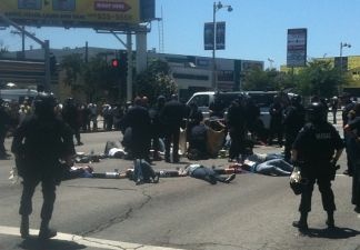 Los Angeles Police Department officers use cutting devices to free protesters who had linked their arms together at the corner of Wilshire Boulevard and Highland Avenue in L.A.