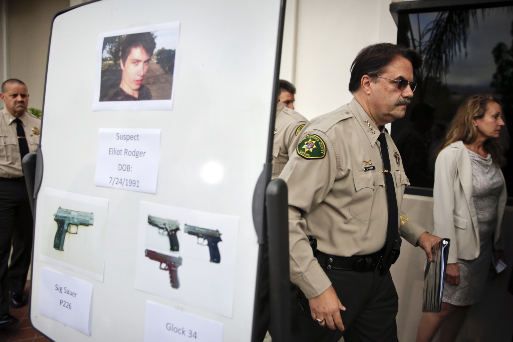 APTOPIX College Community Shooting Santa Barbara County Sheriff Bill Brown, right, walks past a board showing the photos of suspected gunman Elliot Rodger and the weapons he used in Friday night's mass shooting that took place in Isla Vista, Calif., after a news conference on Saturday, May 24, 2014, in Santa Barbara, Calif. Sheriff's officials say Rodger, 22, went on a rampage near the University of California, Santa Barbara, stabbing three people to death at his apartment before shooting and killing three more in a crime spree through a nearby neighborhood. (AP Photo/Jae C. Hong)