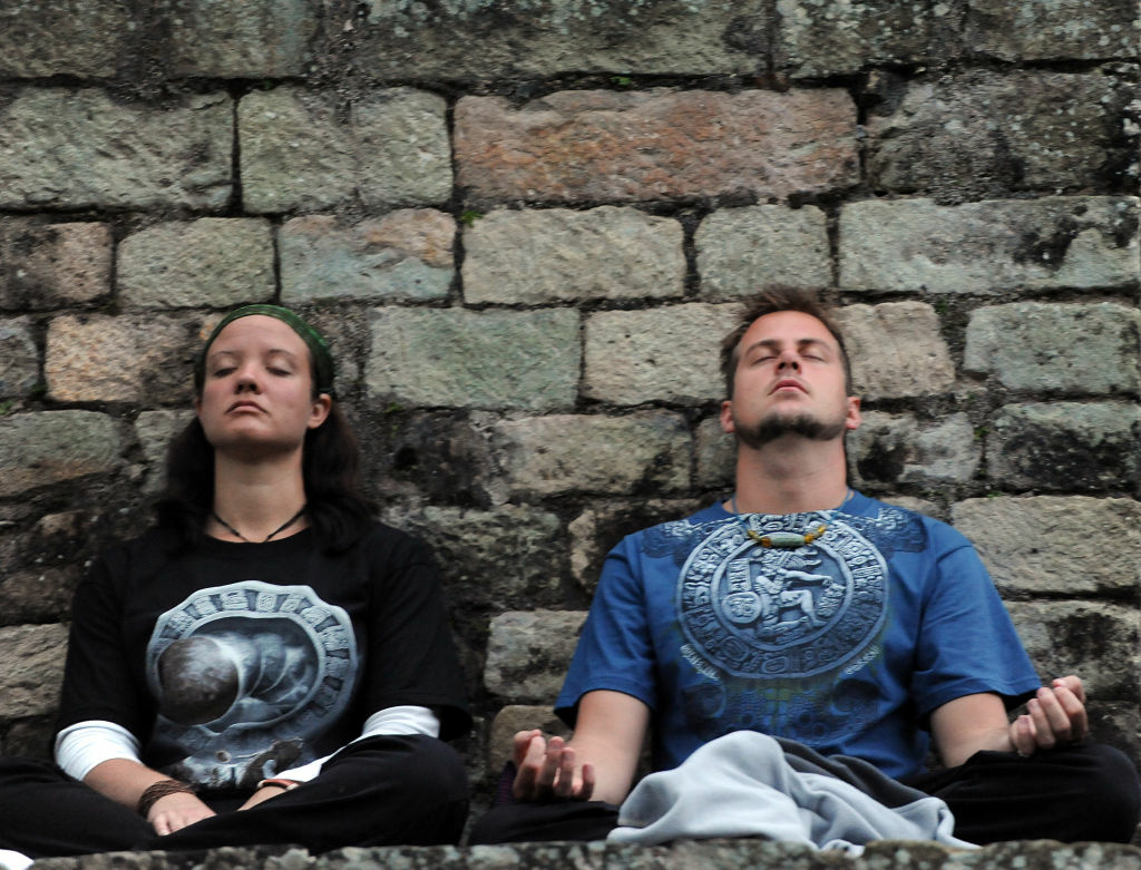 HONDURAS-MAYA-CALENDAR-CELEBRATION A couple meditates during celebrations for the end of the Mayan cycle known as Bak'tun 13 and the start of the Maya new age, on December 21, 2012, in the Copan archaeological park, 400km northwest of Tegucigalpa.