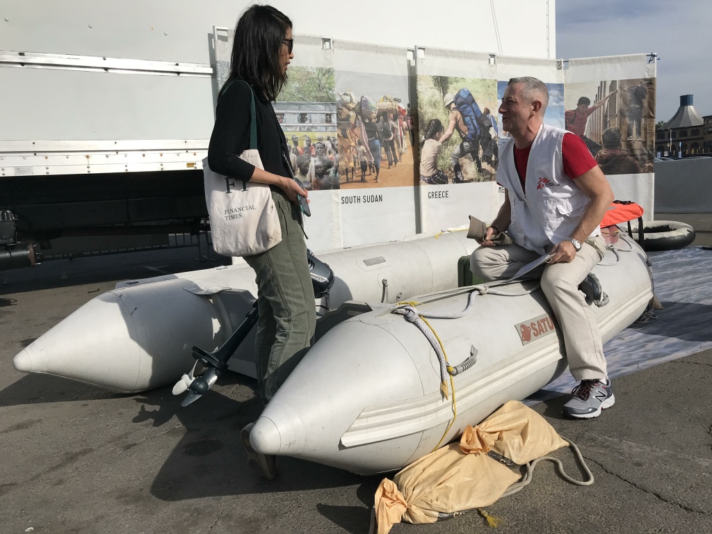 John Fiddler speaks with KPCC's Josie Huang at the boat that's meant to represent how displaced people would flee war-torn countries by sea. Fiddler says this boat would be a more luxurious example John Fiddler speaks with KPCC's Josie Huang at the boat that's meant to represent how displaced people would flee war-torn countries by sea. Fiddler says this boat would be a more luxurious example