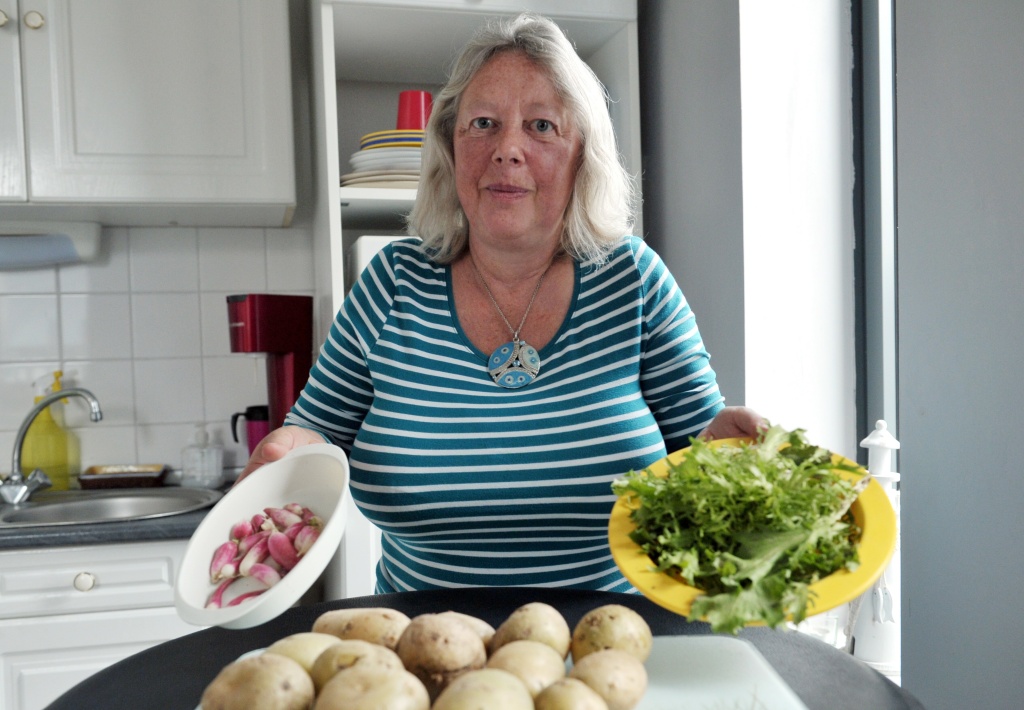 FRANCE-ENVIRONMENT-SOCIAL-WASTE Andree Nieuwjaer shows radishes, lettuce and potatoes in her kitchen, on November 27, 2015 in Roubaix, northern France. She and her family are part of the 101 households that took on the