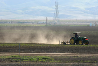 Dust rises as a farmer plows a field in Mendota, California in the state's San Joaquin Valley on March 11, 2009.