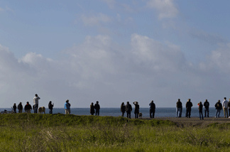 People line a hill overlooking the bay to watch as tsunami surges hit on March 11, 2011 in Half Moon Bay, California.