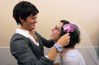 Danielle Peregory (L) places a veil on the head of her future wife Kelly Jones as they wait in line to get a marriage license at San Francisco City Hall August 12, 2010 in San Francisco, California.
