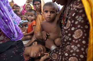 Exhausted and hungry displaced flood victims rest as they wait for a place to go asdter the flood waters forced them to escape from their homes August 10, 2010 in Sukkur, Pakistan.