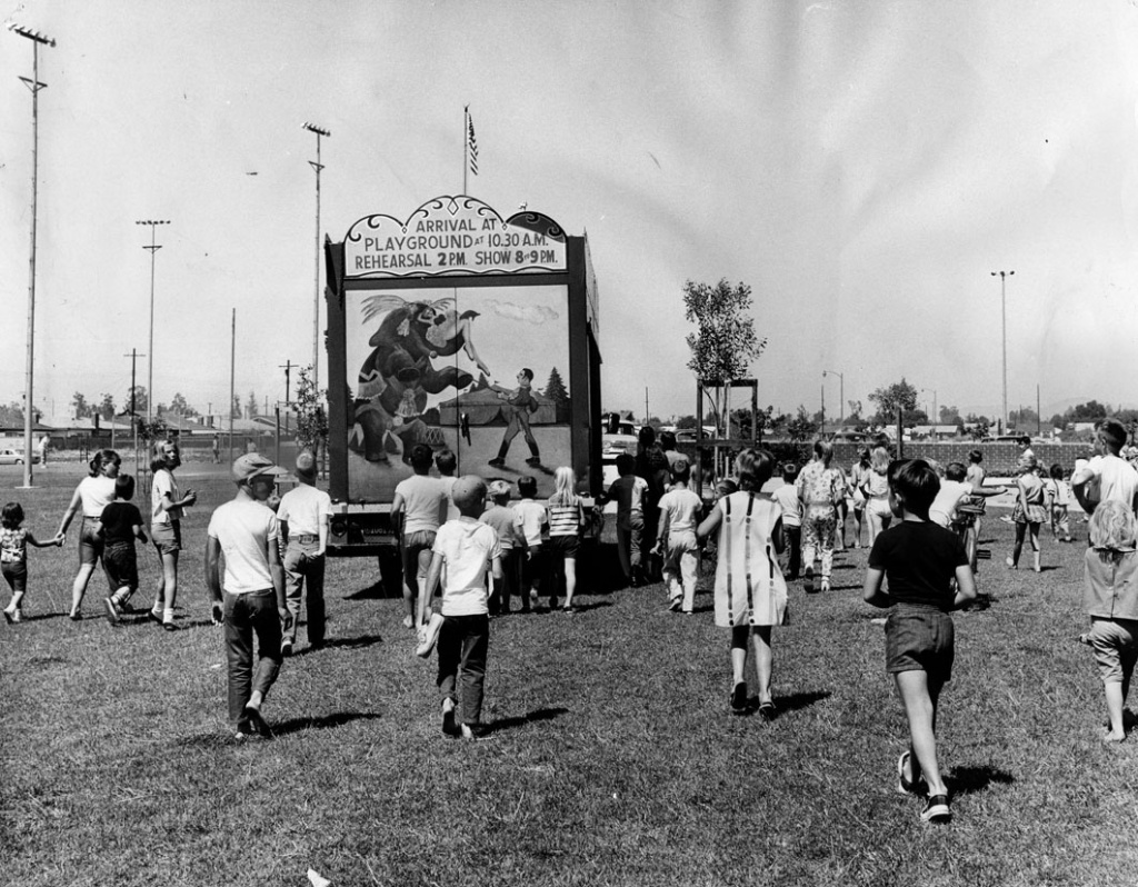 LA Traveling Circus Children follow a truck as it drives into position at Granada Hills Playground to set up the 1964 Combined Traveling Circus and Kiddie Carnival. Photo dated: July 4, 1964.
