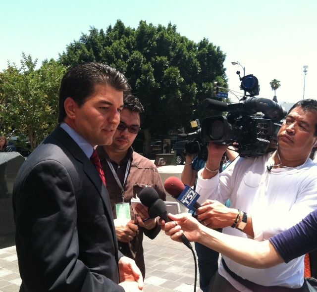 Assistant U.S. Attorney Joseph Akrotirianakis speaks to reporters following the court appearance of three former Cudahy city officials.