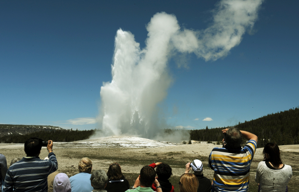 Tourists watch the 'Old Faithful' geyser Tourists watch the 'Old Faithful' geyser which erupts on average every 90 minutes in the Yellowstone National Park, Wyoming on June 1, 2011. Yellowstone National Park, was established by the U.S. Congress and signed into law by President Grant on March 1, 1872. The park is located primarily in the U.S. state of Wyoming, though it also extends into Montana and Idaho and was the first national park in the world. It is known for its wildlife and its many geothermal features, especially the Old Faithful Geyser.