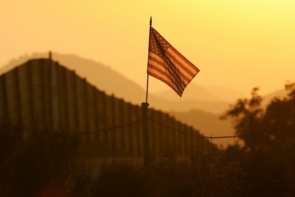 US-Mexico Border Fence Impacts Borderlands Environment A U.S. flag put up by activists who oppose illegal immigration flies near the US-Mexico border fence in an area where they search for border crossers October 8, 2006 near Campo, California. The activists want the fence expanded into a fully-lit double-fenced barrier between the US (R) and Mexico. US Fish and Wildlife Service wardens and environmentalists warn that a proposed plan by US lawmakers to construct 700 miles of double fencing along the 2,000-mile US-Mexico border, in an attempt to wall-out illegal immigrants, would also harm rare wildlife. Wildlife experts say cactus-pollinating insects would fly around fence lights, birds that migrate by starlight in the desert wilderness would be confused, and large mammals such as jaguars, Mexican wolves, Sonoran pronghorn antelope, and desert bighorn sheep would be blocked from migrating across the international border, from California to Texas.
