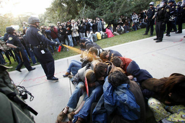 Cop who pepper-sprayed UC Davis students during an Occupy protest in 2011 is seeking worker's compensation. (File photo: In this Friday, Nov. 18, 2011, photo University of California, Davis Police Lt. John Pike uses pepper spray to move Occupy UC Davis protesters while blocking their exit from the school's quad Friday in Davis, Calif.).