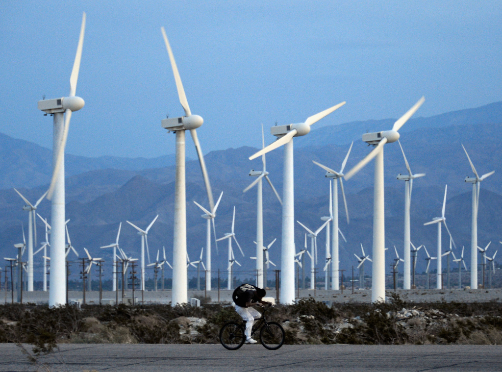 California Continues To Lead U.S. In Green Technology A man rids his bike against the win as giant wind turbines are powered by strong winds at sunset on March 27, 2013 in Palm Springs, California. According to reports, California continues to lead the nation in green technology and has the lowest greenhouse gas emissions per capita, even with a growing economy and population.