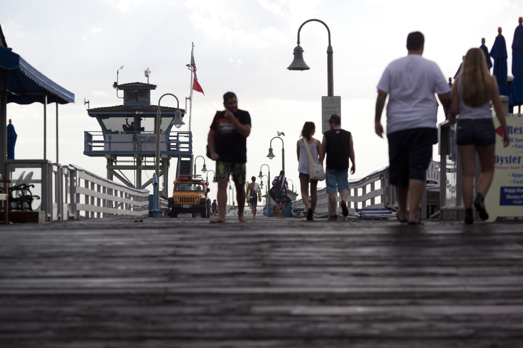 HOT WEATHER 00 Beachgoers walk along the San Clemente Pier after a storm brought rain to Orange County Tuesday afternoon. Republicans are battling for the Orange County stronghold.