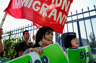 Protesters with Coalition for Humane Immigrant Rights of Los Angeles (CHIRLA) hold signs as they march during an anti Secure Communities program demonstration on August 15, 2011 in Los Angeles.