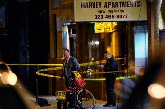 Los Angeles Police Department detectives stand outside the Harvey Apartments on Dec. 1, 2010 in Los Angeles. According to reports, a suspect thought to be connected with the murder of publicist Ronni Chasen, fatally shot himself in this Hollywood hotel.