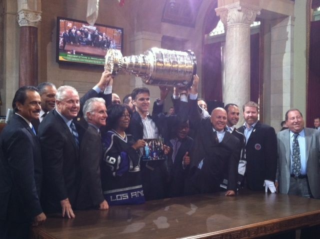 Luc Robitaille lifts up the Stanley Cup, surrounded by members of the Los Angeles City Council.