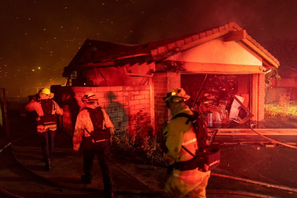 Firefighters work to save homes from the Saddleridge Fire in the Porter Ranch section of Los Angeles, California, on October 11, 2019. Firefighters work to save homes from the Saddleridge Fire in the Porter Ranch section of Los Angeles, California, on October 11, 2019.