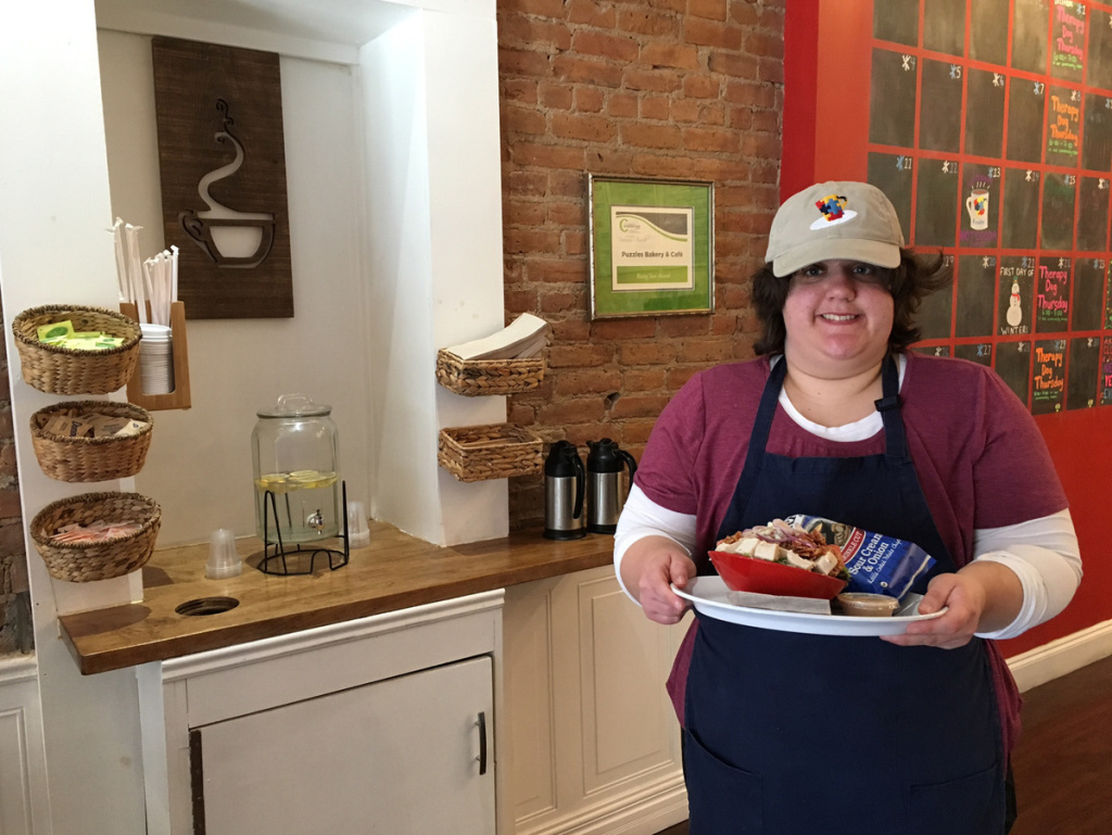 img_0254-56-c5e8f01331de87baa3c0b69099ca6fe4209e4703-s1200.jpg Madaline Hannon, 23, a café attendant at Puzzles takes a sandwich to a customer. Hannon has autism. Her parents say the job has helped her become more social and independent.