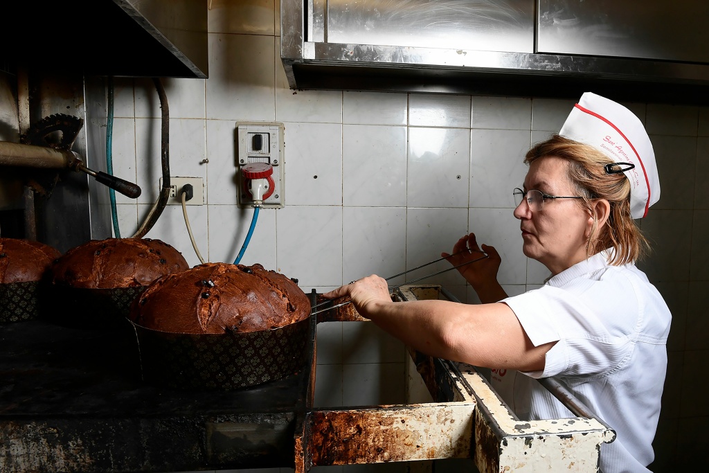 ITALY-GASTRONOMY-PANETTONE-CHRISTMAS A pastry chef takes a panettone, a traditional Christmas sweet bread, out of the oven, on December 6, 2017 at the Pasticceria San Gregorio in Milan.