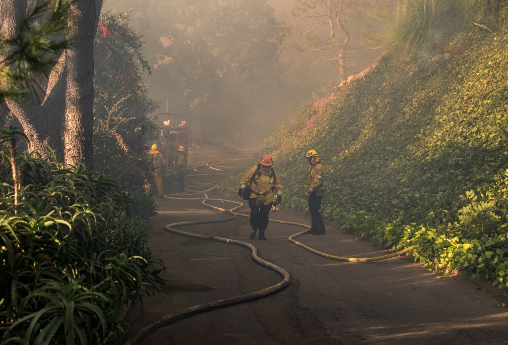 Skirball Fire Firefighters work to save burning houses along Linda Flora Drive during the Skirball Fire in Los Angeles, California, December 6, 2017. The Skirball Fiire ignited before 5 a.m. on Wednesday and quickly engulfed 50 acres.