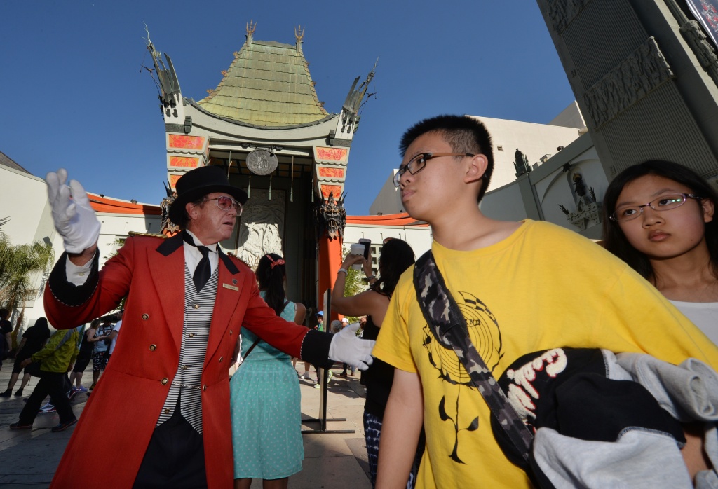 US-CHINA-ENTERTAINMENT-HOLLYWOOD-TOURISM Chinese tourists walk past the TCL Chinese Theatre on Hollywood Boulevard in Hollywood, California on October 24, 2014.