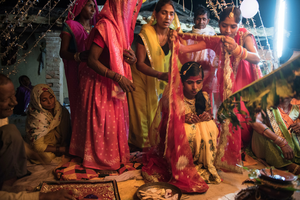 Instagram photographer The 14-year-old bride is draped in a red cloth as she waits for the groom to arrive for the wedding rituals in the courtyard of her house.