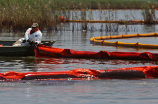Contract workers from BP use booms to trap oil from floating away so that it can be collected near a marsh near Pass a Loutre on June 1, 2010 near Venice, Louisiana.