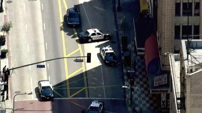 LAPD patrol cars cordon off the 600 block of S. Broadway following a botched jewelry store robbery in which one alleged robber was shot.