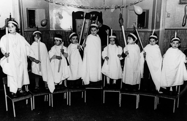 Ran Yaniv, aged 3, fourth child from left, with friends, lighting Hannukah candles at the Jewish kindergarten in London.