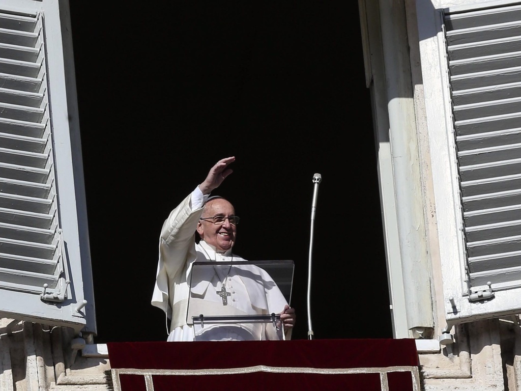 Pope Francis waves from the window of his rooms at the Vatican to faithful at St. Peter's Square at his Sunday Angelus prayer at the Vatican City on Sunday. Pope Francis waves from the window of his rooms at the Vatican to faithful at St. Peter's Square.