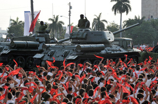 Mercer 17176 Cuban pioneers wave their kerchiefs simulating waves, on April 16, 2011, around the vintage URSS-made T-34/85 tank (R) and the SU-100 self-propelled-gun used by former Cuban President Fidel Castro in the Bay of Pigs battle, during the parade at Revolution Square in Havana to commemorate the 50th anniversary of the Bay of Pigs victory and the beginning of the Cuban Communist Party 60th Congress.