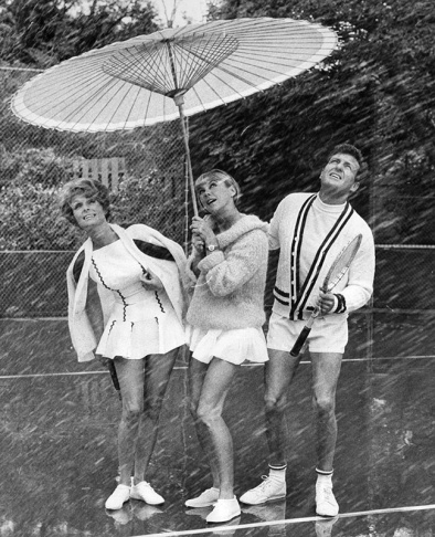 1938: People walk along the flooded L.A. River near the Dayton Avenue Bridge. In the background, a railroad bridge hangs in a twisted heap after one of the pilings has collapsed. (Photograph courtesy of the Los Angeles Public Library)