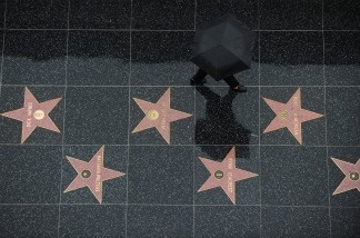 A tourist walks in the rain on the stars of the Hollywood Walk of Fame in Hollywood, California.